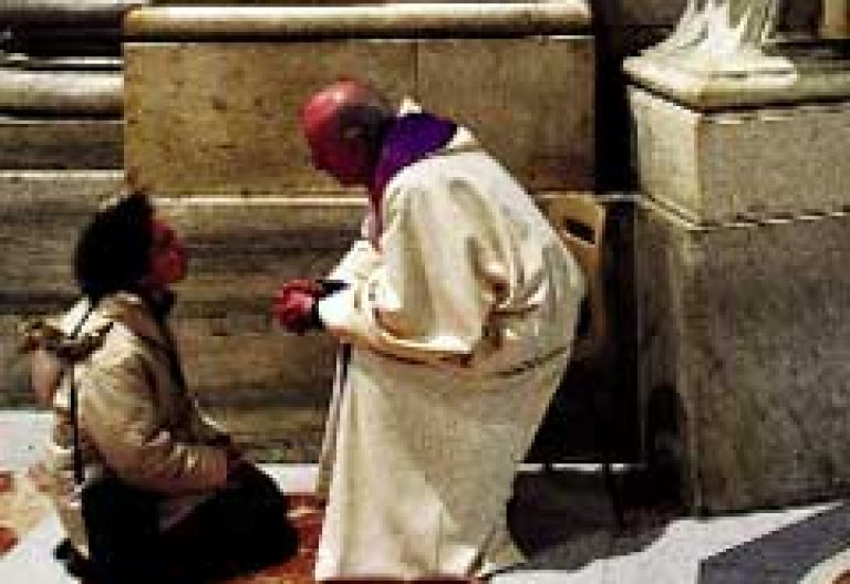 sacerdote sentado en un banco confesando a una mujer de rodillas en el Vaticano