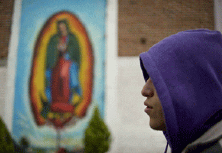 joven en México con una imagen de la Virgen de Guadalupe