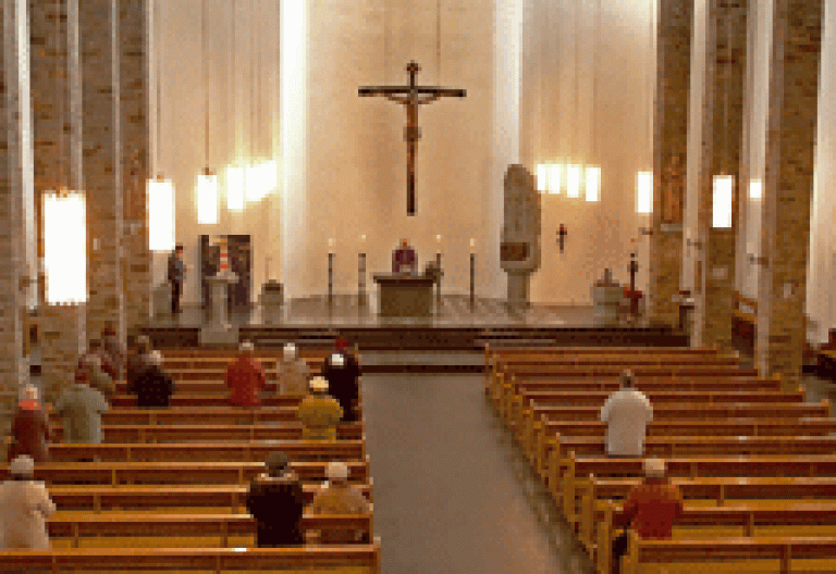 gente en misa en una iglesia casi vacía