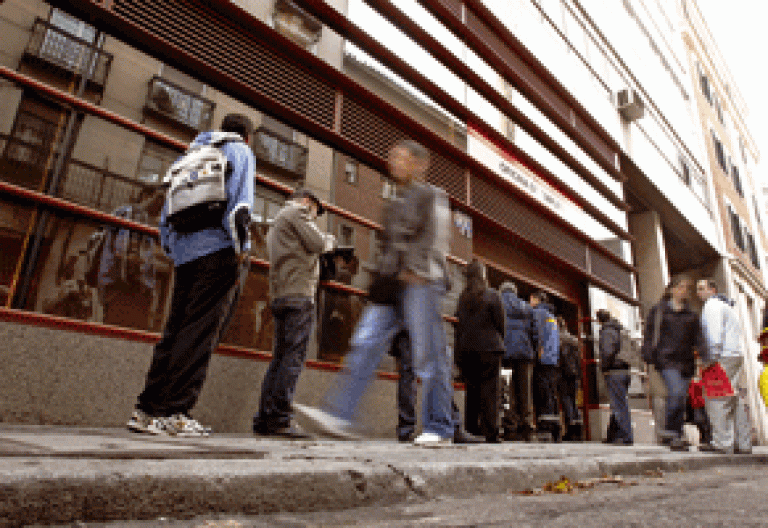 gente parados desempleados haciendo cola ante una oficina del INEM