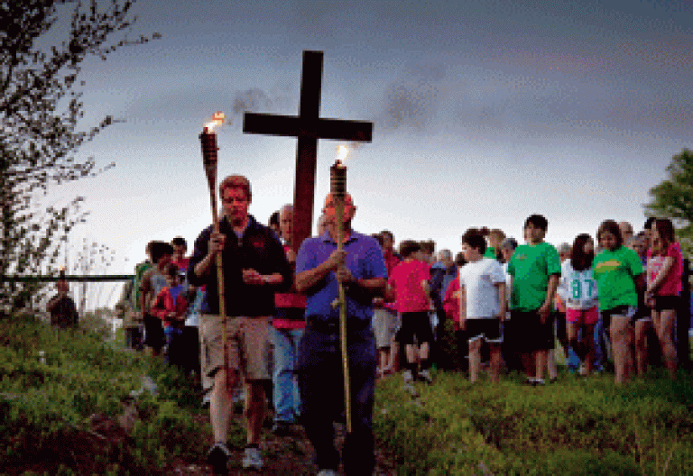 procesión de unos niños y jóvenes con cruz en el campo