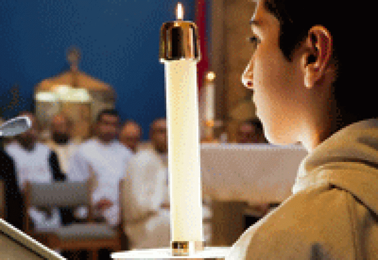 un monaguillo porta una vela durate una eucaristía