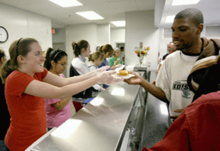 voluntaria católica en un comedor con un inmigrante