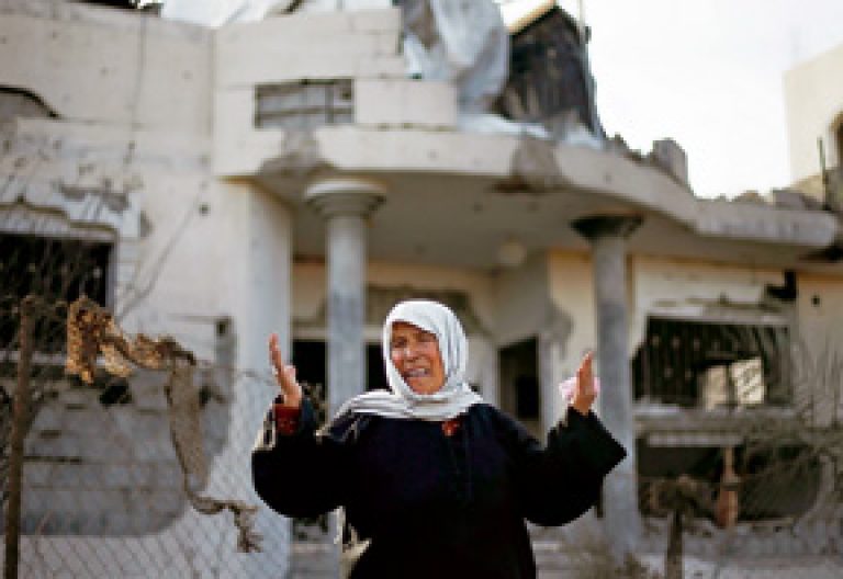 mujer llorando y gritando en ciudad bombardeada en Gaza