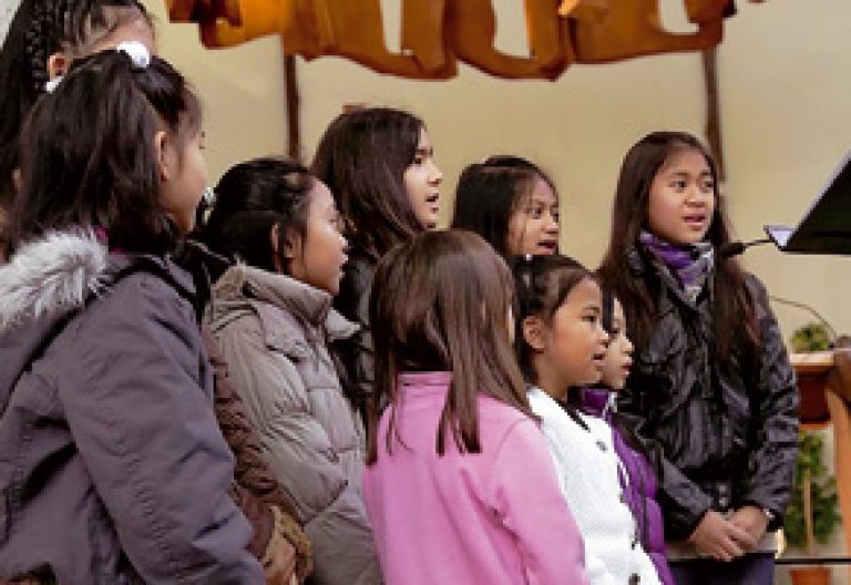 grupo de niñas inmigrantes en el coro de la parroquia