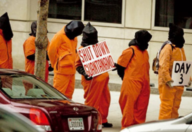 grupo de personas disfrazadas en una protesta contra las torturas en Guantánamo