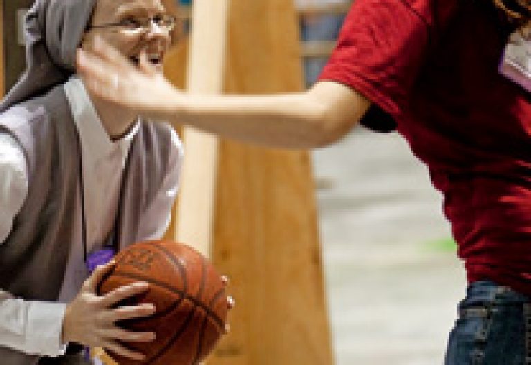 una religiosa juega al baloncesto con una chica