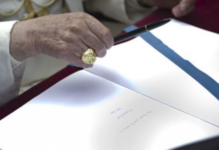 papa Benedicto XVI firma en un libro