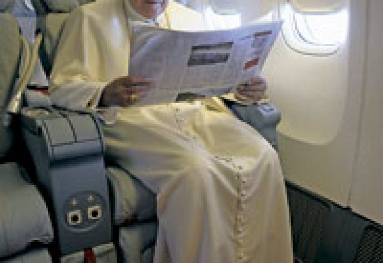 papa leyendo el periódico en el avión papal
