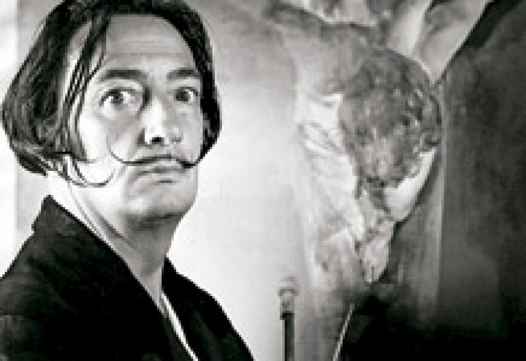 Salvador Dalí posa frente a un cuadro con un Cristo