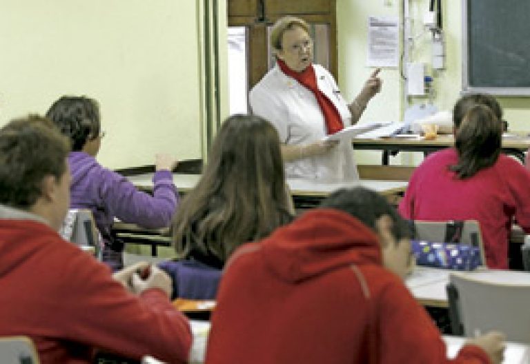 profesora con alumnos en un aula en escuela concertada