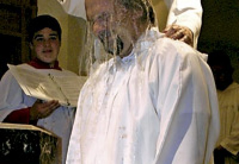 sacerdote bautiza a un hombre adulto