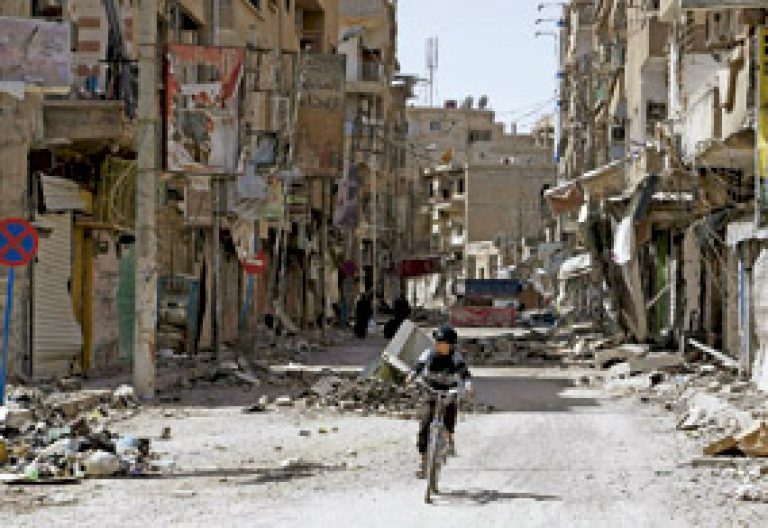 niño en bicicleta en Siria calles destrozadas por la guerra