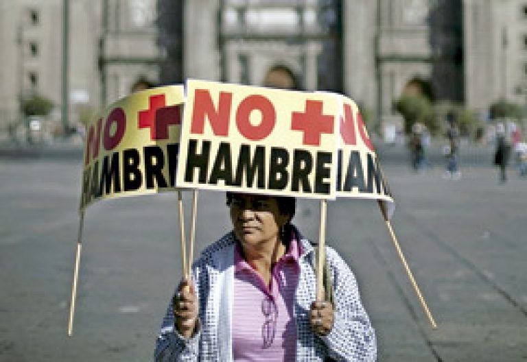 mujer porta varios carteles con protesta con la leyenda No más hambre