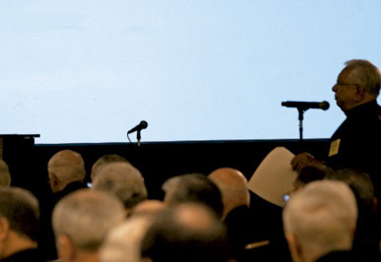 sacerdote pronuncia una conferencia desde un micrófono ante el público