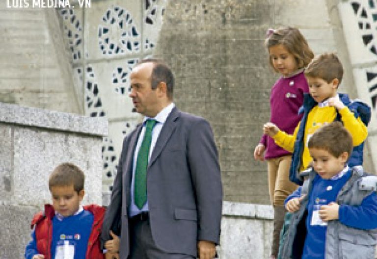 padre con cuatro hijos saliendo de misa en la parroquia