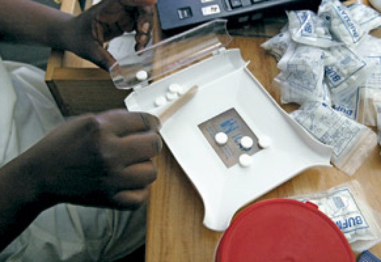 médico africano manipula pastillas