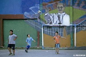 niños juegan en campo de fútbol en villa miseria en Buenos Aires