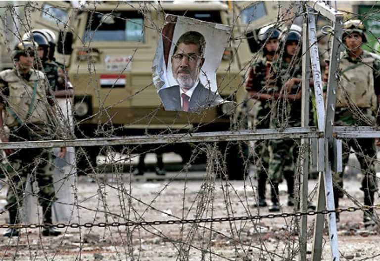 Egipto tras el golpe de estado el ejército guarda una verja en la que cuelga la foto de Mursi
