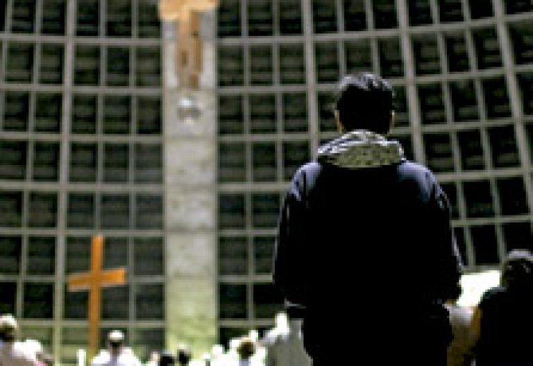 joven brasileño rezando en una iglesia