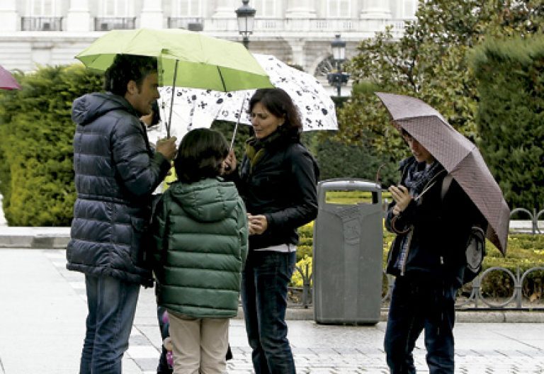 familia en la calle con paraguas en un día de lluvia