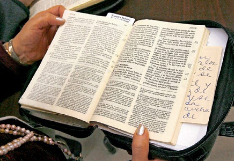 mujer leyendo la Biblia en la Iglesia