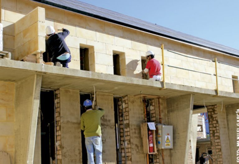 obreros construyen nueva iglesia parroquial en La Antilla, Huelva, contratados por la Iglesia local