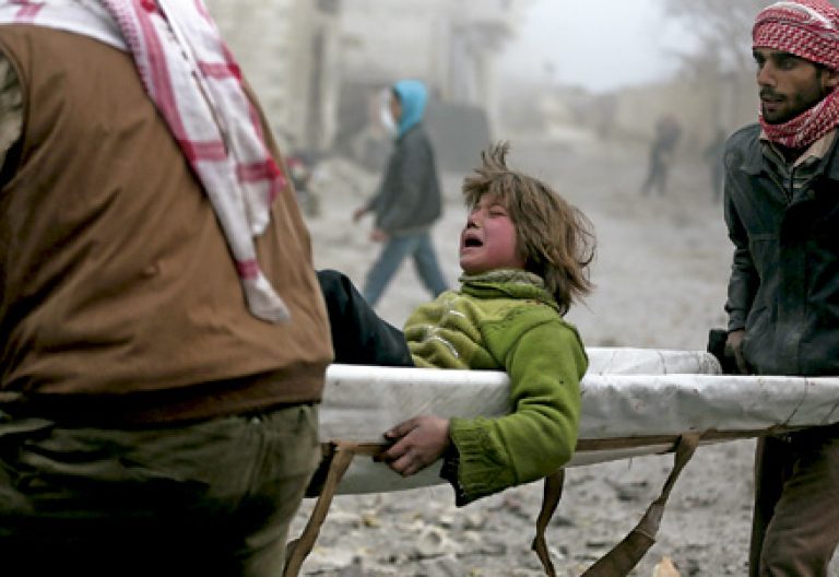 niño trasladado en camilla después de ser herido en Siria