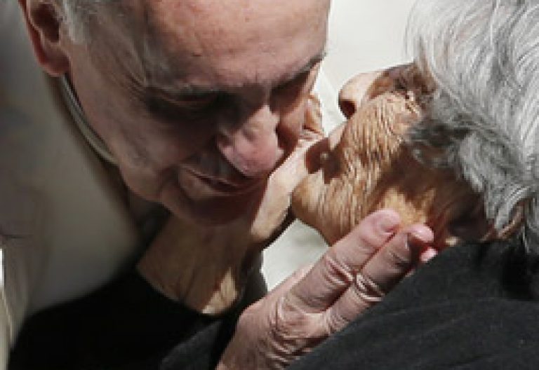 papa Francisco besa a una mujer anciana