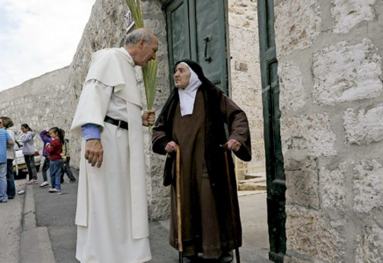 un religioso habla con una monja con hábito