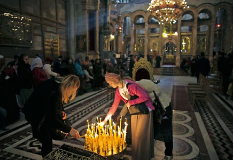 cristianos encienden velas y rezan en el Santo Sepulcro de Jerusalén