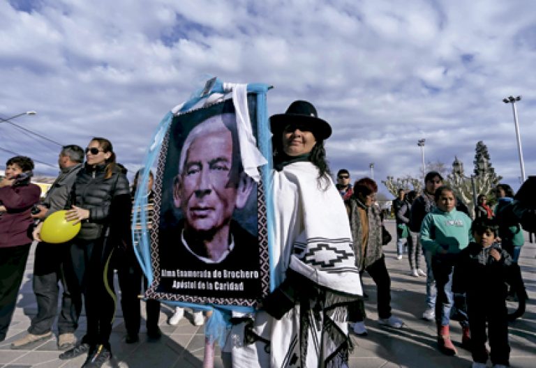 mujer lleva un póster con la imagen del Cura Brochero, primer sacerdote argentino que será canonizado en 2016