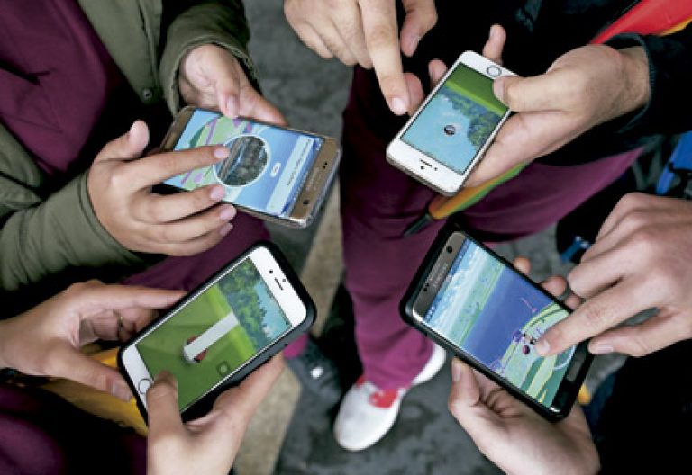 grupo de personas jugando a Pokemon Go en sus teléfonos móviles