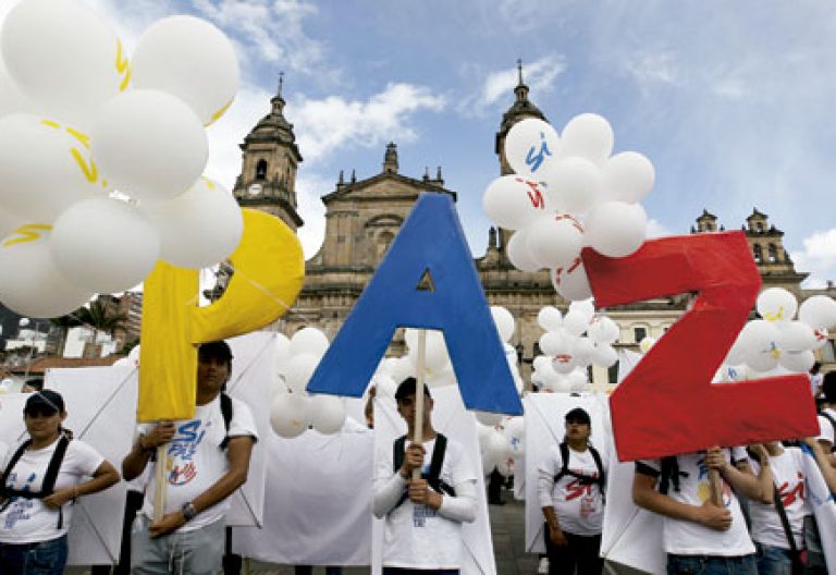 grupo de personas forman la palabra Paz frente a la catedral de Bogotá firma de acuerdos de paz Gobierno FARC Colombia 26 septiembre 2016