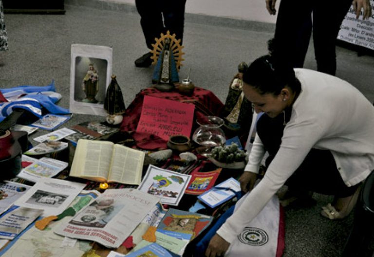 mujer en un encuentro de Comunidades Eclesiales de Base en América Latina prepara materiales para compartir por los participantes