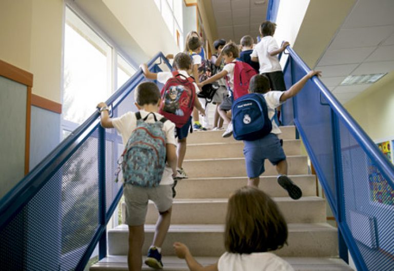 niños en el colegio alumnos de primaria subiendo escaleras en la escuela para ir a clase