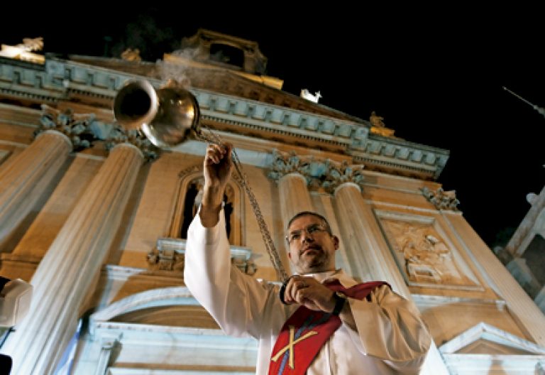 diácono permanente con el incensario a las puertas de una iglesia