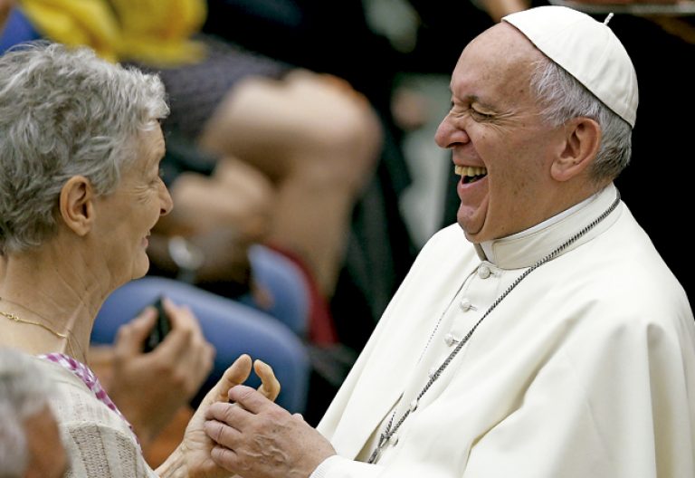 papa Francisco saluda y se ríe con una mujer mayor durante una audiencia