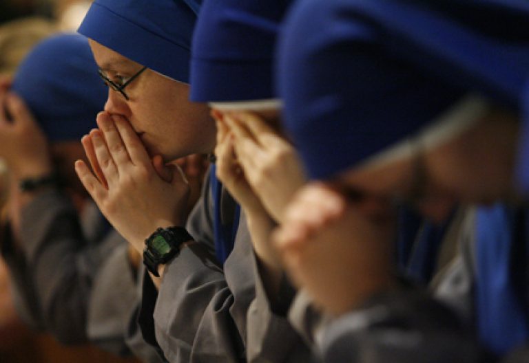 religiosas rezando jóvenes arrodilladas con las manos en la cara