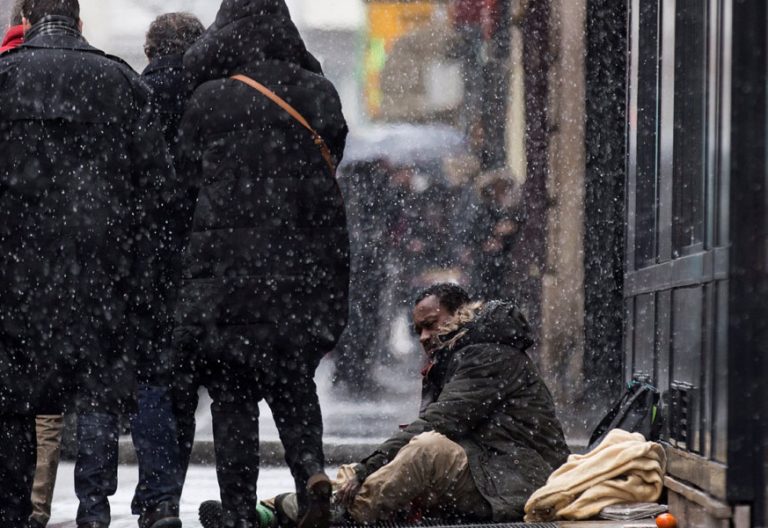 Un inmigrante pide limosna en una calle de París durante la oleada de frío polar sufrida en febrero de 2018