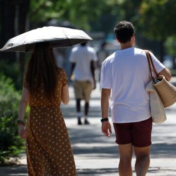 Una pareja pasea por un parque en Madrid bajo temperaturas muy altas