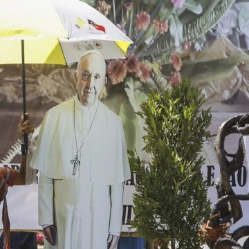 Un ciudadano, en las calles de Dili con una imagen del Papa