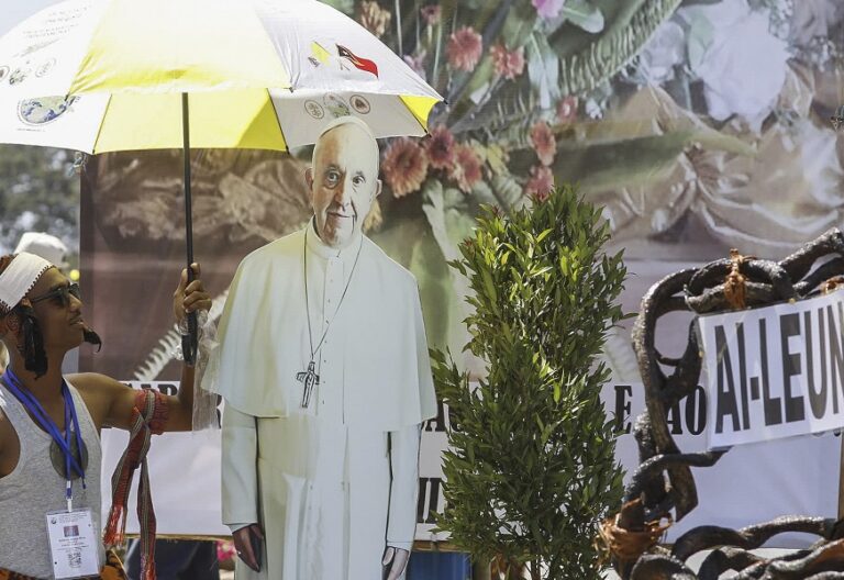 Un ciudadano, en las calles de Dili con una imagen del Papa