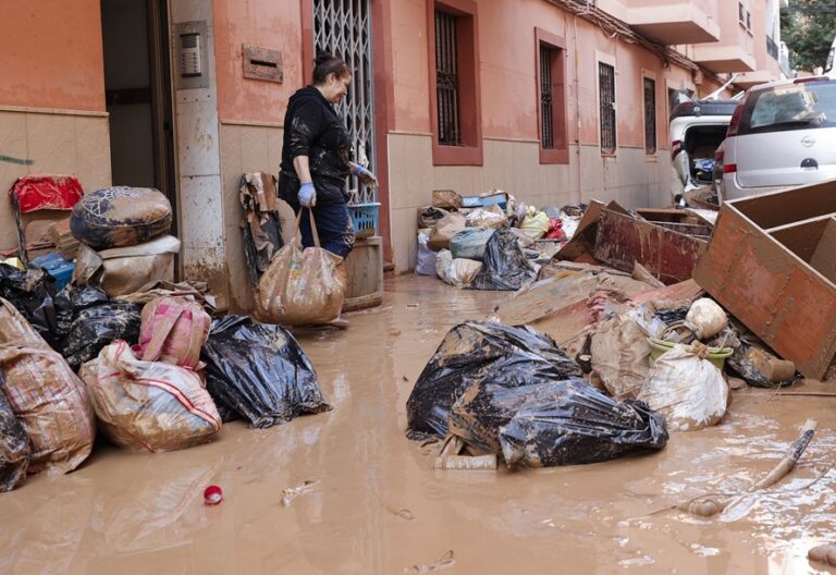 CATARROJA (VALENCIA), 31/10/2024.- Una mujer saca de su vivienda sus pertenecias tras las intensas lluvias caídas por la fuerte dana, este jueves en Catarroja. Catarroja, una de las localidades afectadas por la dana que asoló este martes la provincia de Valencia, se afana por restablecer los suministros cortados a consecuencia del temporal y en ofrecer ayuda humanitaria a los vecinos.EFE/Manuel Bruque