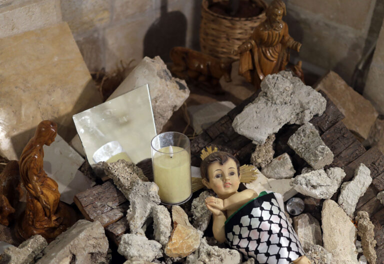 Un nacimiento con una figura del niño Jesús envuelto en una kufiya (pañuelo palestino) y rodeado de escombros en la Iglesia Evangélica Luterana de Belén.