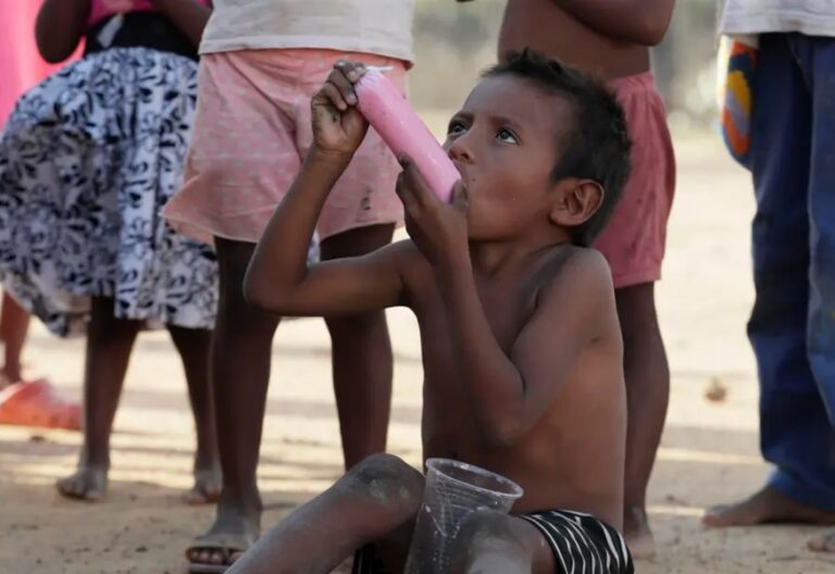 Un niño indígena wayúu come hielo saborizado el 14 de mayo de 2022 en la comunidad Witka, en