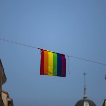 Bandera lgtbi en una calle de Madrid con una iglesia al fondo