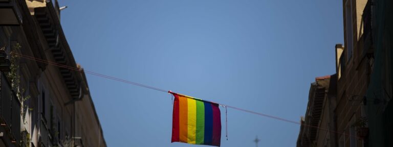 Bandera lgtbi en una calle de Madrid con una iglesia al fondo