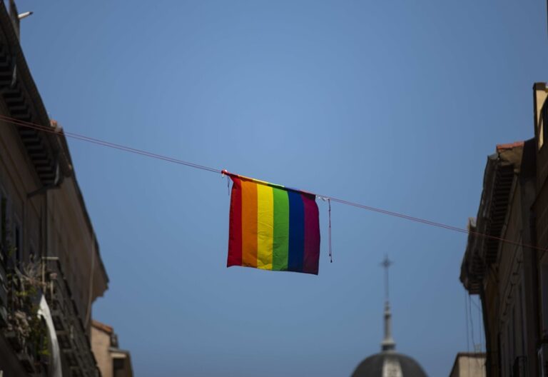 Bandera lgtbi en una calle de Madrid con una iglesia al fondo