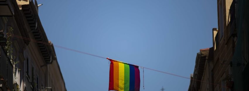 Bandera lgtbi en una calle de Madrid con una iglesia al fondo